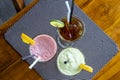 Avocado smoothie, watermelon shake and cold tea in a glass on a wooden table. Tropical drink concept . Top view, closeup Royalty Free Stock Photo