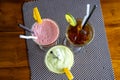 Avocado smoothie, watermelon shake and cold tea in a glass on a wooden table. Tropical drink concept . Top view, closeup Royalty Free Stock Photo