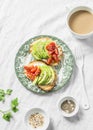 Avocado, soft cheese, cherry tomatoes sandwich and tea with milk on a light background, top view. Healthy snack Royalty Free Stock Photo