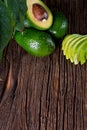 Avocado split in half on old wooden table with free space for your text. Royalty Free Stock Photo