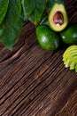 Avocado split in half on old wooden table with free space for your text. Royalty Free Stock Photo