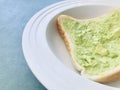 Avocado on white bread in white round plate. select focus.