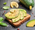 Avocado toast - bread with avocado slices on natural slate serving board. Top view Royalty Free Stock Photo