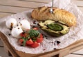 Avocado toast, cherry tomato and poached eggs on wooden background. vegetarian food, healthy diet concept. Royalty Free Stock Photo