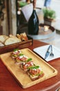 Avocado Toast with Cherry Tomatoes and Feta Cheese, Topping with Rocket leaves. Served on wooden plate with sliced bread. Royalty Free Stock Photo