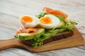 Avocado toast with egg, salmon, lettuce on the cutting board Royalty Free Stock Photo