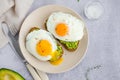 Avocado toast with fried egg and sea salt on a plate on a grey background. A healthy breakfast or lunch. Horizontal orientation Royalty Free Stock Photo