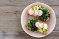 Avocado toast with kale and radish above view on rustic wood