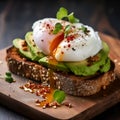 Avocado toast with poached egg and microgreens on dark rye bread, close up. Sandwich with guacamole oar avocado dip and poached