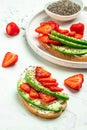 Avocado toast with strawberries, soft cheese and chia seeds on a light background. healthy Breakfast or lunch. Keto diet. Food Royalty Free Stock Photo