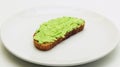 Avocado Toast on a White Plate on a White Background. Royalty Free Stock Photo