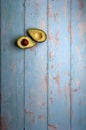 avocados, cut and uncut, on a light blue background of deteriorated wood