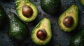avocados with water drops on them on a table top with a black surface and a few more avocados on the table Royalty Free Stock Photo