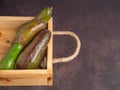 Avocados in a wooden crate on the old table in the kitchen. Royalty Free Stock Photo