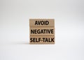 Avoid negative self-talk symbol. Concept words Avoid negative self-talk on wooden blocks. Beautiful white background. Business and