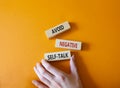 Avoid negative self-talk symbol. Concept words Avoid negative self-talk on wooden blocks. Businessman hand. Beautiful orange