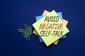 Avoid negative self-talk symbol. Concept words Avoid negative self-talk on yellow steaky note. Beautiful deep blue background.