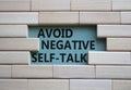 Avoid negative self-talk symbol. Concept words Avoid negative self-talk on wooden blocks. Beautiful grey green background.