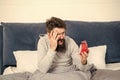 Awaken man screaming in panic looking at alarm clock in bed in morning, oversleeping Royalty Free Stock Photo