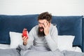 Awaken man screaming in panic looking at alarm clock in bed in morning, oversleeping Royalty Free Stock Photo