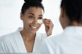 African woman applies patches to reduce dark circles