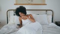 Awaking girl yawning bed at morning. African woman reading phone laying pillow Royalty Free Stock Photo