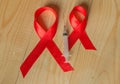 Awareness red ribbon and syringe on wooden background: world day of fight against AIDS, promotion public support for the