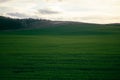 Awe-inspiring landscape with fresh short green grass and shining blue sky with bright sun under clouds and shadows from Royalty Free Stock Photo