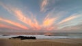 Awe-inspiring scene of a vibrant pink sunset sky illuminating the sandy beach below