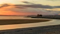 Awe-inspiring sunset with a vibrant orange and yellow sky over a picturesque lighthouse