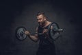 Bodybuilder holds barbell over dark grey background.