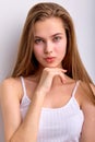 Awesome caucasian female with natural long brown hair posing at camera, in white undershirt