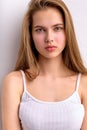 Awesome caucasian female with natural long brown hair posing at camera, in white undershirt