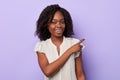 Awesome charming afro girl in white stylish blouse pointing with her finger.