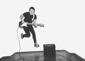 Awesome crazy fashion young musician rock guitar player jumps with passion in studio. Stylish rocky emotional man. Black Royalty Free Stock Photo