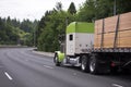 Awesome customized big rig white and green semi truck with flat