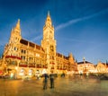 Awesome evening view of Marienplatz - City-center square & transport hub with towering St. Peter`s church, two town halls and a