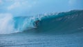 Awesome young surfer rides a beautiful emerald barrel wave in sunny Tahiti. Royalty Free Stock Photo