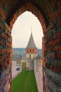 Awesome landscape view of high and thick stone walls with watch tower. View from the window of tower. Red brick border Royalty Free Stock Photo