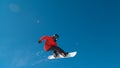 Awesome male snowboarder riding on a sunny day doing a trick high up in the air. Royalty Free Stock Photo