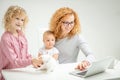 Awesome positive red-haired girl browsing the Net with her little children Royalty Free Stock Photo