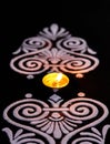 Awesome shot of white rangoli and beautiful tea lamp on black background. diwali concept