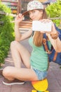 Awesome skateboarder girl making selfie on mobile phone