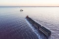 Awesome train rides on rail in the water with white salt on the background of beautiful blue sky. aerial view, view from