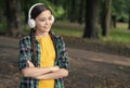 Awesome travel technology. Little girl listen to music in woods. Small child wear headphones in casual style. New