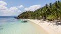 Awesome tropical landscape in the Philippines. Traditional filipino boat parked in a dreamed beach with palm trees, white sand and Royalty Free Stock Photo