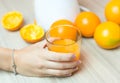 Awesome woman in the kitchen squeezing fresh orange juice with an electric juicer