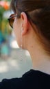 Awesome young woman wearing beautiful earring with rhinestones