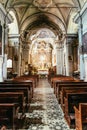 Historic catholic church: Wooden pews in a row and altar width crucifix