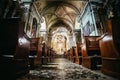 Historic catholic church: Wooden pews in a row and altar width crucifix